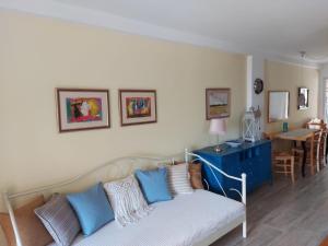 a living room with a couch with blue pillows at Premantura Studio apartman in Premantura