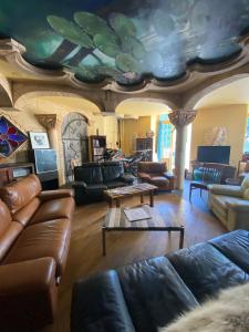 salon ze skórzanymi meblami i malowanym sufitem w obiekcie HOME LE SOFT Vic sur Cère w mieście Vic-sur-Cère