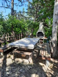 una mesa de picnic y bancos frente a un árbol en Apartman Kapelica, en Labin
