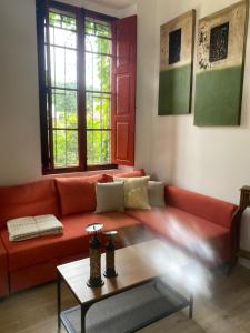 sala de estar con sofá rojo y mesa en El Balcón del Eume, Cantina Río Covés, en Puentedeume