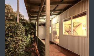 einem externen Blick auf ein Haus mit einer Veranda und einer Treppe in der Unterkunft Cable Beachside Villas in Broome