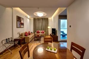 a living room with a table and a couch at Rose Park Hotel - Al Barsha, Opposite Metro Station in Dubai