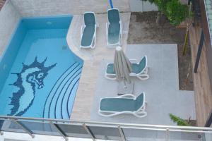an overhead view of a swimming pool with chairs and an umbrella at BEGONVİL VİLLA in Belek
