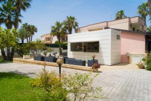 a white building with a restaurant in front of a building at Vaia Residence in Torre dell'Orso