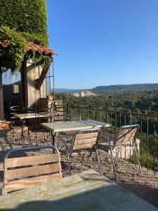 a table and chairs on a balcony with a view at EVEN Bistrot in Évenos