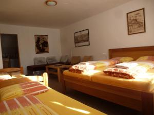 クボヴァ・フチにあるUbytování Lyžařská školaのベッドルーム1室(ベッド2台付)、リビングルームが備わります。