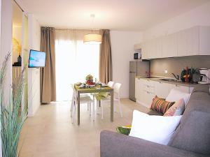 sala de estar y cocina con sofá y mesa en Residence Green Life, en Bibione