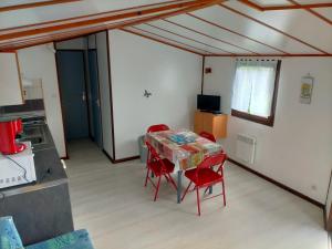 a dining room with a table and red chairs at EURL kaza évasion services in Cabariot