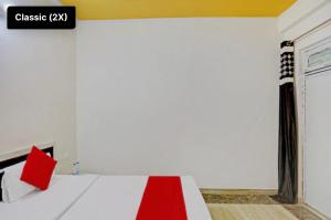 een kamer met een bed met een rode en witte deken bij Hotel NK guesthouse in Sikandra