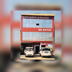 zwei Autos, die vor einem mas Hotel geparkt sind in der Unterkunft Hotel NK guesthouse in Sikandra