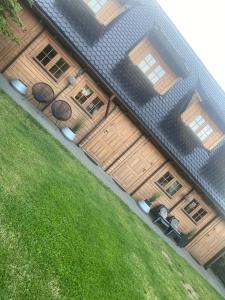 a house with wooden doors on the side of it at Domki Drewniane Całoroczne in Krynica Morska +2 photos