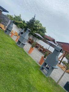 a row of tables and benches on a lawn at Domki Drewniane Całoroczne in Krynica Morska