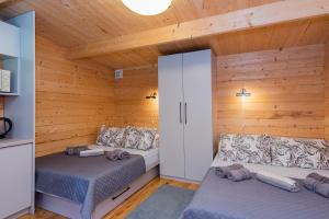 a room with two beds in a log cabin at Kunigiškės, svečių namai in Palanga