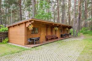 una piccola cabina nel bosco con tavolo e panche di Kunigiškės, svečių namai a Palanga