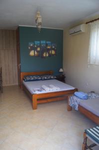a bedroom with two beds and a green wall at Vrachos Sunrise Apartment in Vrachos