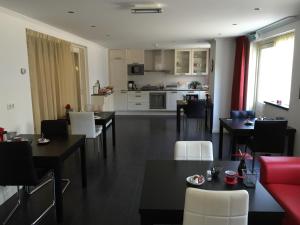 a living room with tables and chairs and a kitchen at Cecilia - Catharina B&B in Joure