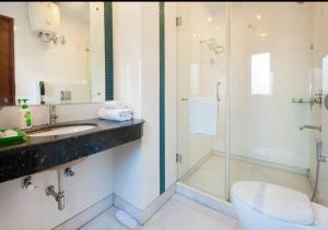 a bathroom with a shower and a sink and a toilet at Asian Suites IFFCO Metro Station Gurugram in Gurgaon +33 photos