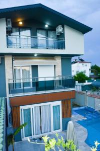 a house with a balcony and a swimming pool at BEGONVİL VİLLA in Belek