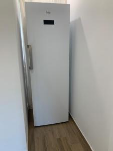 a white refrigerator in a room with a wooden floor at Casa Rosalinda in Figari