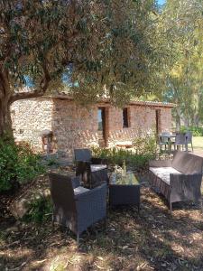 eine Terrasse mit Stühlen und einem Tisch unter einem Baum in der Unterkunft Villetta Sisini - Key to Villas in Capoterra