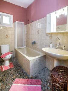 a bathroom with a tub and a sink and a toilet at Ioanna Villa in Skala Marion +29 photos