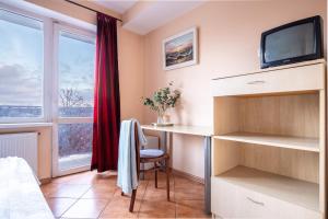 a bedroom with a desk and a tv and a window at Mara in Vilnius