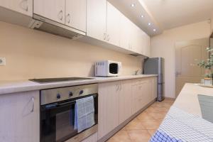 a kitchen with white cabinets and a microwave at Mara in Vilnius