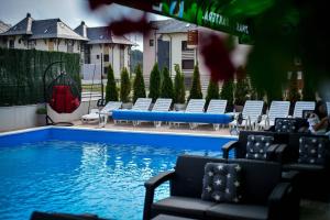 uma piscina com espreguiçadeiras ao lado de uma casa em Apartment Stefan in Vila Katalina Lux em Zlatibor