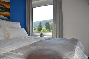 a bedroom with a bed and a large window at Nikolaierhaus in Feldkirchen in Kärnten