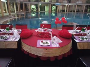a round table with plates of food on it next to a pool at Royal Orchid Central Kireeti Hampi in Hampi