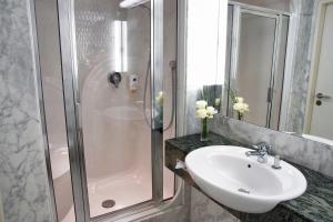 ein Bad mit einem Waschbecken und einer Dusche in der Unterkunft Atlanta Hotel International Leipzig in Leipzig