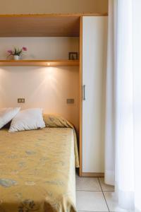Hotel Loretta & Dependance في تشرفيا: غرفة نوم بسرير وخزانة فيها نبات