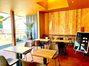 志摩市にあるカブクリゾートの木製の壁とテーブルと椅子が備わるレストラン