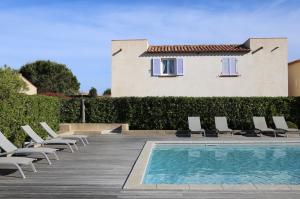 a swimming pool with lounge chairs and a house at Casa Mia in Lecci