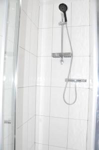 a shower with a shower head in a bathroom at Virtue House in Woolwich