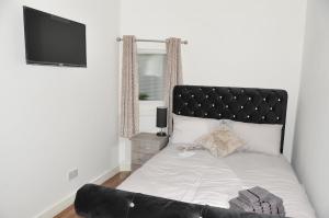 a bedroom with a large bed with a black headboard at Virtue House in Woolwich
