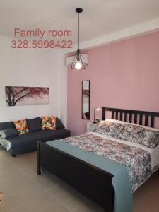 a bedroom with a bed and a couch at Family Room Scicli in Scicli