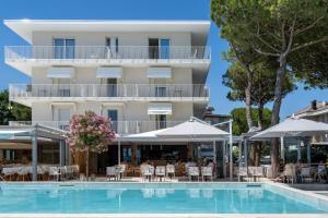 a hotel with a swimming pool in front of a building at Hotel Bauer & Sporting in Lido di Jesolo