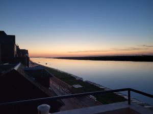 z balkonu roztacza się widok na rzekę o zachodzie słońca w obiekcie Vue et terrasse panoramique sur la Baie de Somme w mieście Saint-Valéry-sur-Somme