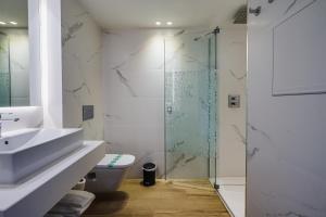 コマルガにあるHotel Brisamar Suitesのバスルーム(トイレ、ガラス張りのシャワー付)