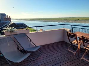 balkon ze stołem i krzesłami oraz oceanem w obiekcie Vue et terrasse panoramique sur la Baie de Somme w mieście Saint-Valéry-sur-Somme
