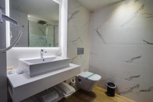 コマルガにあるHotel Brisamar Suitesの洗面台とトイレを備えた白いバスルーム +37枚の写真