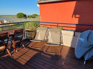 dwa krzesła i stół na tarasie w obiekcie Vue et terrasse panoramique sur la Baie de Somme w mieście Saint-Valéry-sur-Somme