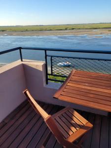 drewniany stół i krzesło na pokładzie łodzi w obiekcie Vue et terrasse panoramique sur la Baie de Somme w mieście Saint-Valéry-sur-Somme