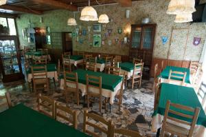 um restaurante vazio com mesas e cadeiras verdes em Tre Fiumi em Ronta