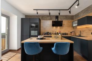 a kitchen with two blue chairs at a counter at CASA GIUSEPPE Luxury house with an amazing view in Labin