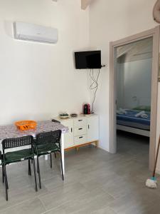 Habitación con mesa, sillas y cama en Casa azzurra, en Reitani
