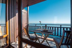 una mesa y sillas en un balcón con vistas al océano en Guest House Doctor's House, en Sozopol