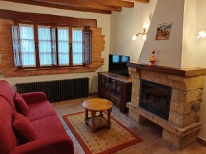 sala de estar con sofá rojo y chimenea en EL PALACIO, en Ruente