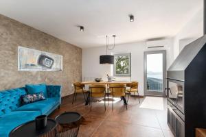 a living room with a blue couch and a table at CASA GIUSEPPE Luxury house with an amazing view in Labin